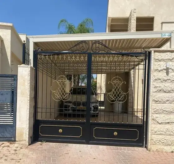 שער חנייה כפול עם עיטורי פליז ולוחות מתכת מלאים