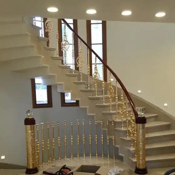 מעקה מדרגות עם עמודי פליז מוזהבים בחלל כפול