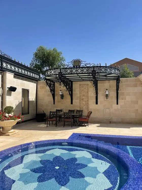 סככת ברזל מעוטרת מעל הג׳קוזי בחצר האחוזה