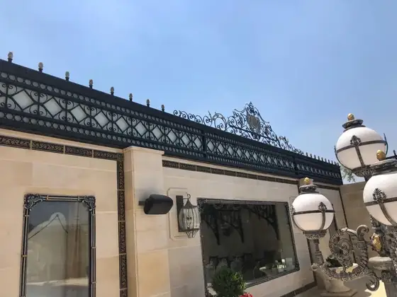 עיטור ברזל מלא לאורך גג האחוזה על רקע שמיים
