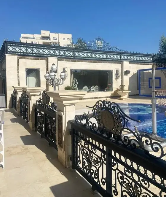 גידור ברזל מעוטר סביב הבריכה בחזית האחוזה